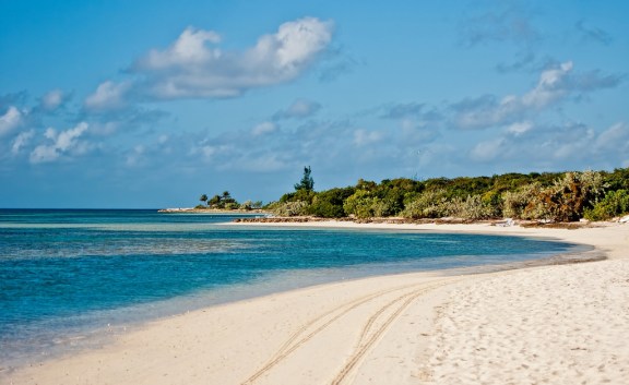 Empty white-sand beach and shallow turquoise water in the Bahamas